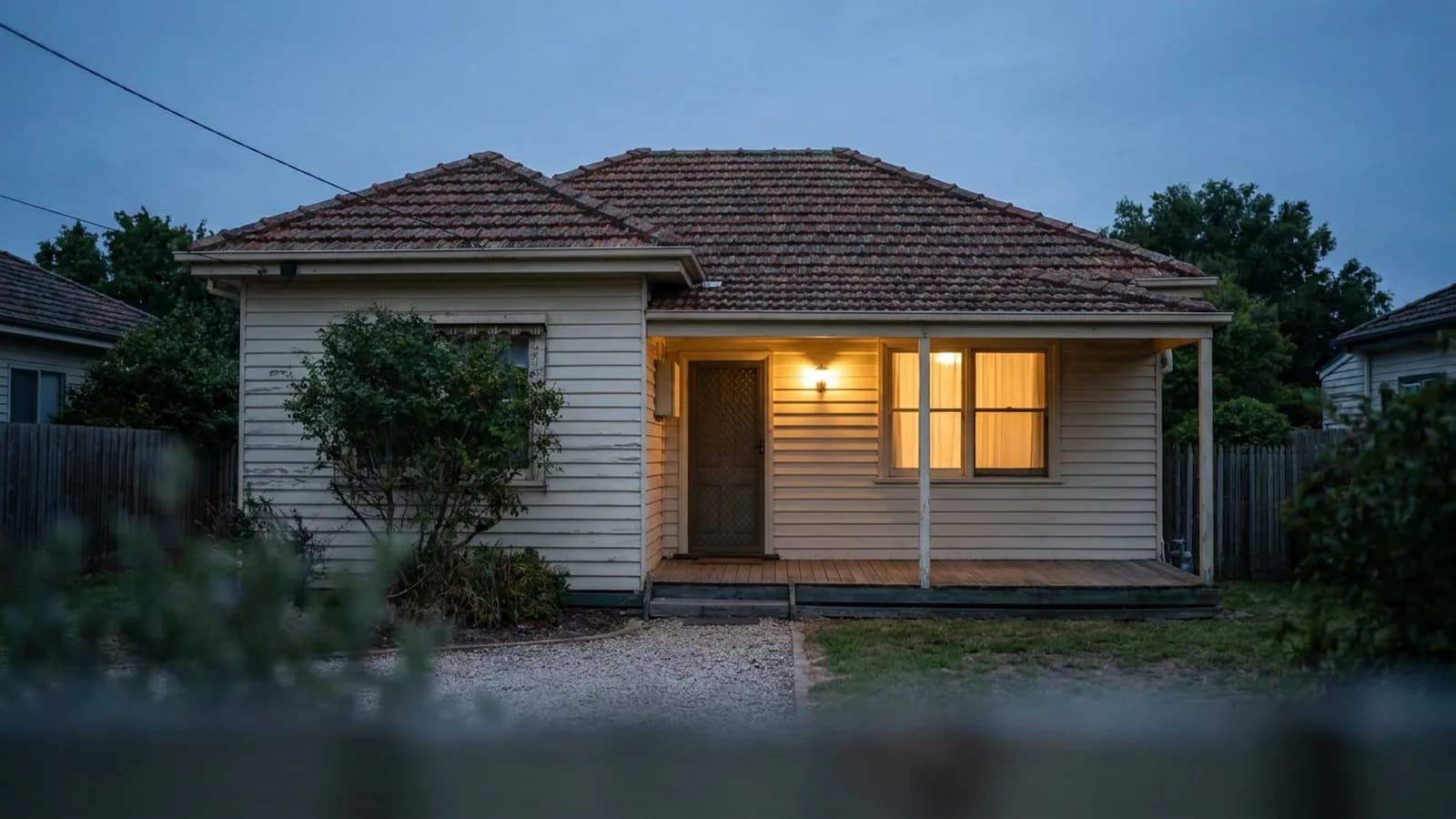A small, simple single-story home with a narrow porch and a single front window
